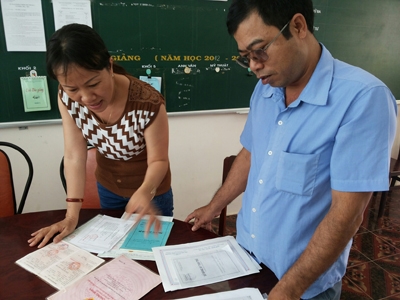 Phụ huynh Đinh Văn Châu, trưng ra một đống giấy tờ nhưng chủ quyền sổ đỏ lại là của anh trai nên không đủ điều kiện cho con nhập học. Ảnh: phạm hùng